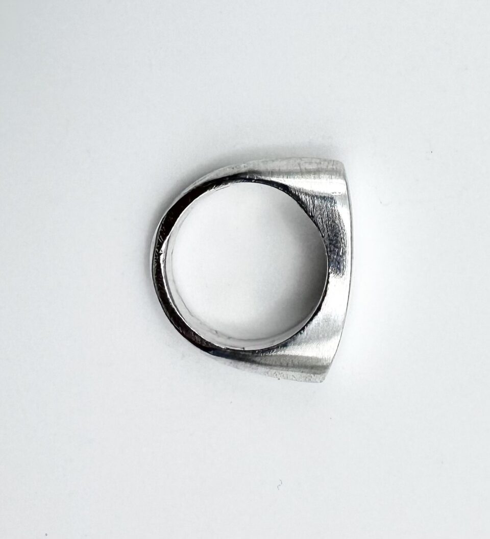 andcrafted minimalist silver geometric ring on white background
