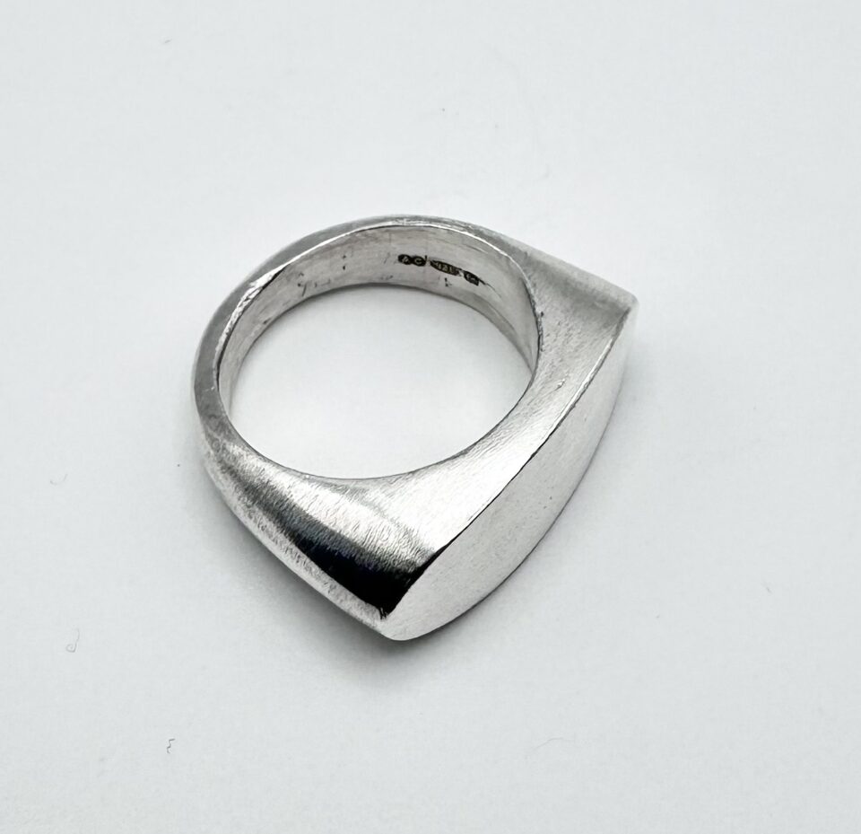 handcrafted minimalist silver geometric ring on white background
