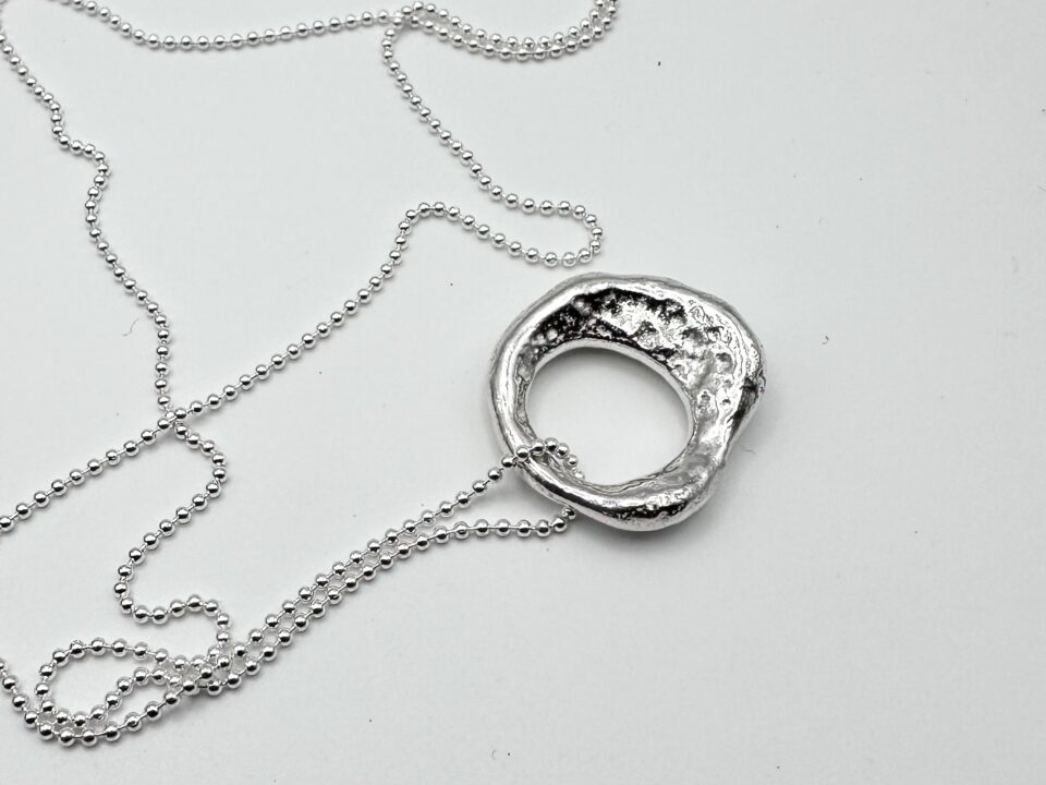 Handcrafter molten silver organic pendant necklace on a silver ball chain, textured and hallmarked artisan jewellery