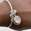 Handmade sterling silver bangle with rose quartz charm on wrist – artisan jewellery by Bohdee.