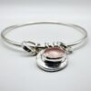 Handmade sterling silver bangle with rose quartz charm on wrist – artisan jewellery by Bohdee.”