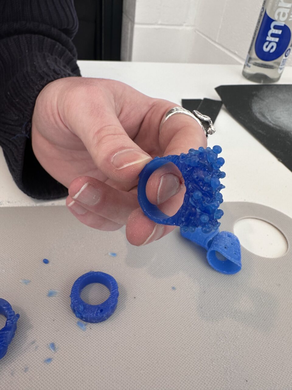 Person carving ring from wav using small hand tools during a jewellery workshop