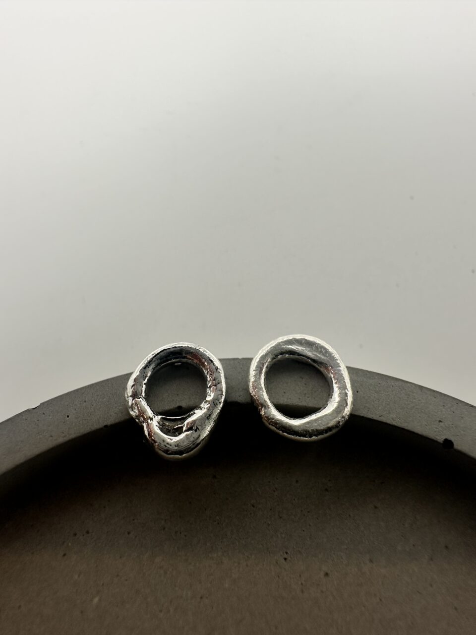 Bohdee small solid silver molten stud earrings with irregular open-circle shapes and softly textured surfaces.